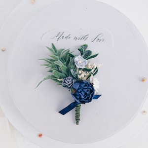 Boutonniere for the groom with dark blue and white flowers. Boho and Rustic Wedding. Flower Brooch with eucalyptus leaves, ruskus and roses