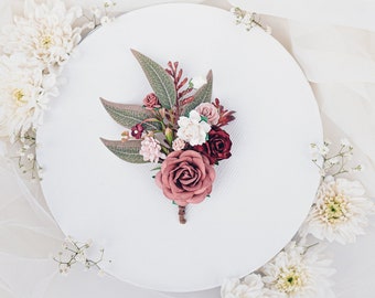 Boutonniere per lo sposo con fiori rosa polverosi e bordeaux. Matrimonio boho e rustico. Spilla fiore con foglie di eucalipto, ruskus, felce