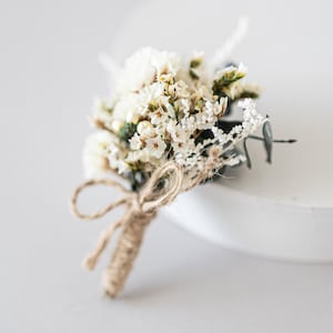 Boutonniere for the groom with dried flowers and eucalyptus. Bohemian buttonhole with preserved flowers for groomsman in white - green