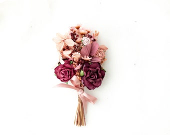 Boutonniere for the groom with dried flowers. Dusty pink and burgundy buttonhole. Corsage for groomsman and best man. Wedding flower brooch