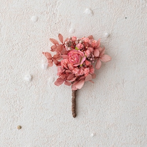 Dusty pink boutonniere for the groom with dried flowers. Groom&#39;s corsage with hydrangea and baby&#39;s breath