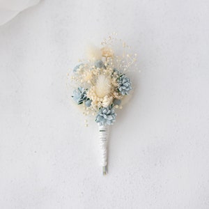 Blue boutonniere for the groom with dried baby's breath and hydrangea. Buttonhole preserved flowers. Corsage for groomsman and best man