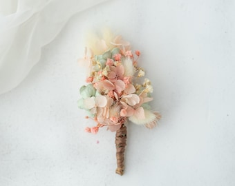 Boutonniere for the groom with dried flowers, hydrangea and gypsophila. Dusty pink and sage green buttonhole. Corsage for groomsman