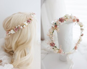 May include: A delicate floral crown with blush pink and white flowers, perfect for a wedding or special occasion.