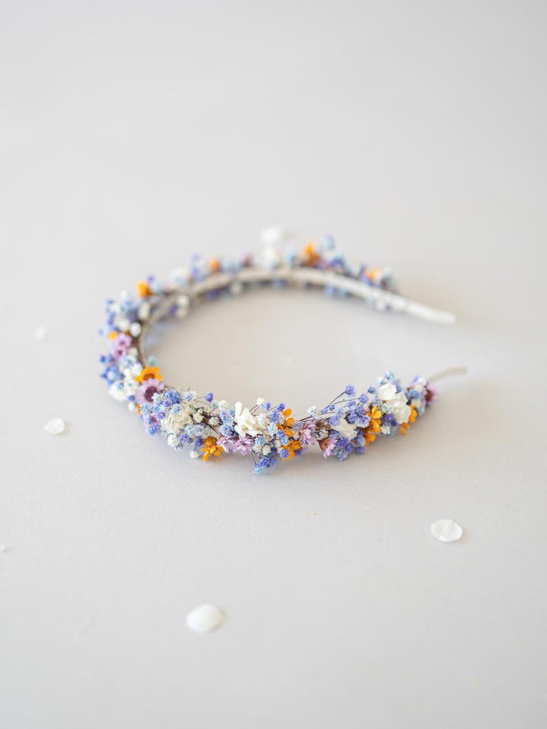 Wunderschönes Boho-Blumenhaarband – handgefertigt mit Trockenblumen, feinen Blüten und zarten Gänseblümchen. Romantische Haaraccessoire perfekt für Hochzeiten, Festivals, Oktoberfest, Weihnachtsfeiern, Fotoshootings oder andere besondere Anlässe. In warmen Herbst- und Winterfarben wie  Orange, Lila, Blau gestaltet. Ein einzigartiges Headpiece im Boho-Stil, ideal für Bräute, Brautjungfern oder festliche Outfits. Zauberhafter Haarschmuck in erdigen Tönen