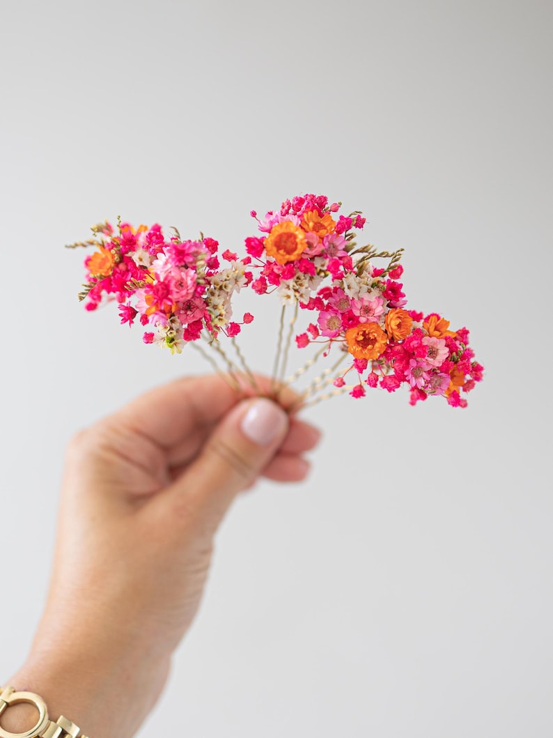 Handgefertigte Haarnadeln mit konservierten Blumen, darunter zarte Gänseblümchen und Schleierkraut in Orange, rosa und pink. Diese romantischen Haarblumen in warmen Herbstfarben sind ein vielseitiger Haarschmuck für Boho-Styles und natürliche Looks. Perfekt als bunter Haarschmuck mit Wildblumen und Schleierkraut für Sommerfeste, Oktoberfest, Hochzeiten, Weihnachten, Brautpartys, Geburtstage, Babypartys. Ideal als herbstliche Accessoires, Haarklammern.
