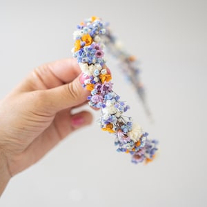 Wunderschönes Boho-Blumenhaarband – handgefertigt mit Trockenblumen, feinen Blüten und zarten Gänseblümchen. Romantische Haaraccessoire perfekt für Hochzeiten, Festivals, Oktoberfest, Weihnachtsfeiern, Fotoshootings oder andere besondere Anlässe. In warmen Herbst- und Winterfarben wie  Orange, Lila, Blau gestaltet. Ein einzigartiges Headpiece im Boho-Stil, ideal für Bräute, Brautjungfern oder festliche Outfits. Zauberhafter Haarschmuck in erdigen Tönen