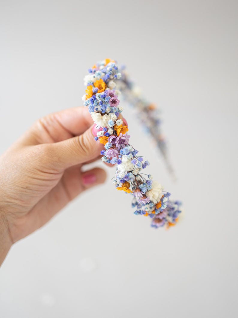 Wunderschönes Boho-Blumenhaarband – handgefertigt mit Trockenblumen, feinen Blüten und zarten Gänseblümchen. Romantische Haaraccessoire perfekt für Hochzeiten, Festivals, Oktoberfest, Weihnachtsfeiern, Fotoshootings oder andere besondere Anlässe. In warmen Herbst- und Winterfarben wie  Orange, Lila, Blau gestaltet. Ein einzigartiges Headpiece im Boho-Stil, ideal für Bräute, Brautjungfern oder festliche Outfits. Zauberhafter Haarschmuck in erdigen Tönen