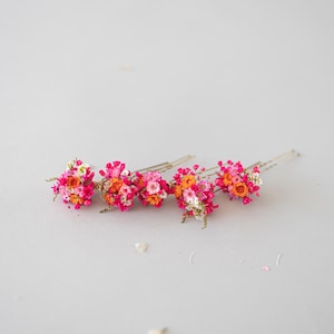 Handgefertigte Haarnadeln mit konservierten Blumen, darunter zarte Gänseblümchen und Schleierkraut in Orange, rosa und pink. Diese romantischen Haarblumen in warmen Herbstfarben sind ein vielseitiger Haarschmuck für Boho-Styles und natürliche Looks. Perfekt als bunter Haarschmuck mit Wildblumen und Schleierkraut für Sommerfeste, Oktoberfest, Hochzeiten, Weihnachten, Brautpartys, Geburtstage, Babypartys. Ideal als herbstliche Accessoires, Haarklammern.