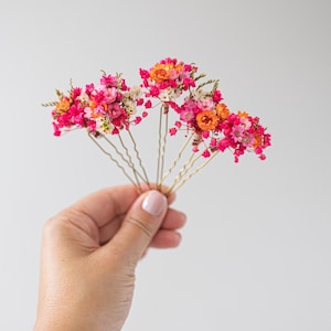 Hair pins with preserved flowers, daisies, and baby’s breath in shades of pink and orange . Autumn hair flowers. Hair accessories with wildflowers and baby’s breath. Colorful hair accessories for summer festivals, Oktoberfest, bridal showers, birthdays, baby showers, weddings, and romantic occasions. Baby’s breath hair clips in natural colors. Rustic headpiece. Winter and Autumn colors. sunset colors. Pink themed weddings. Mexican wedding.