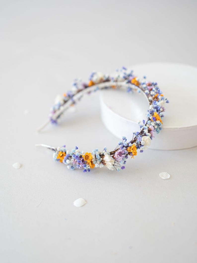 Wunderschönes Boho-Blumenhaarband – handgefertigt mit Trockenblumen, feinen Blüten und zarten Gänseblümchen. Romantische Haaraccessoire perfekt für Hochzeiten, Festivals, Oktoberfest, Weihnachtsfeiern, Fotoshootings oder andere besondere Anlässe. In warmen Herbst- und Winterfarben wie  Orange, Lila, Blau gestaltet. Ein einzigartiges Headpiece im Boho-Stil, ideal für Bräute, Brautjungfern oder festliche Outfits. Zauberhafter Haarschmuck in erdigen Tönen
