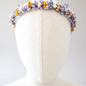 Wunderschönes Boho-Blumenhaarband – handgefertigt mit Trockenblumen, feinen Blüten und zarten Gänseblümchen. Romantische Haaraccessoire perfekt für Hochzeiten, Festivals, Oktoberfest, Weihnachtsfeiern, Fotoshootings oder andere besondere Anlässe. In warmen Herbst- und Winterfarben wie  Orange, Lila, Blau gestaltet. Ein einzigartiges Headpiece im Boho-Stil, ideal für Bräute, Brautjungfern oder festliche Outfits. Zauberhafter Haarschmuck in erdigen Tönen