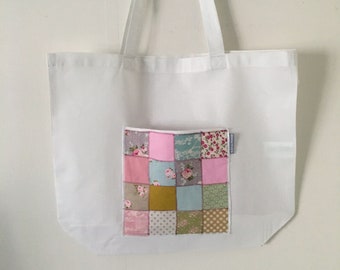 Large white tote bag adorned with a patchwork pocket