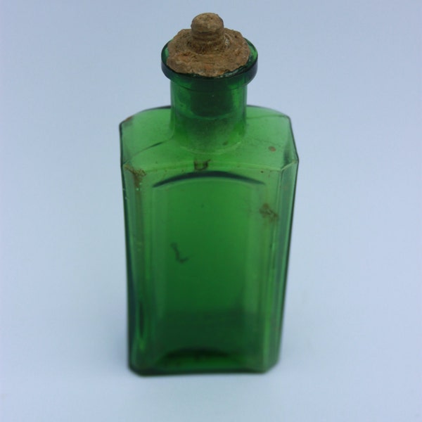 Small green glass bottle with ribbed corners