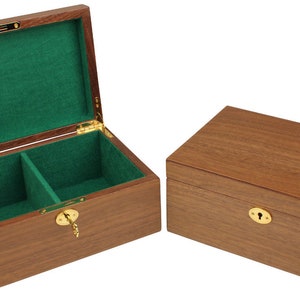 May include: Two wooden boxes with hinged lids. The box on the left is open, revealing a green velvet interior with a divider. Both boxes have a brass keyhole and a brass lock.