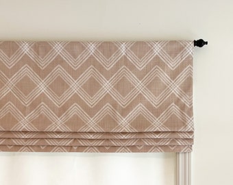 May include: A brown roman shade with a white geometric pattern. The shade is raised, showing the folds of the fabric.