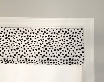 May include: A white roman shade with a black and white dalmatian print pattern.