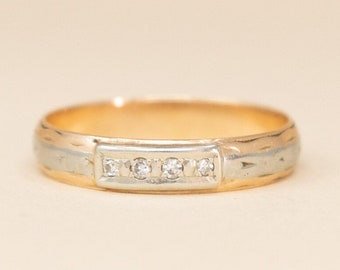 May include: A gold and silver band ring with a row of small diamonds.