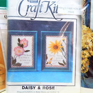 May include: A craft kit featuring two embroidery projects, a rose and a daisy. The kit includes pre-printed fabric, embroidery floss, and instructions. The packaging features a blue background with the words "Daisy & Rose" and "Designed Exclusively for Better Homes and Gardens".