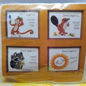 May include: Four colorful embroidered pictures with a reminder to comb your hair, brush your teeth, wash your hands, and wear a smile. Each picture has a different animal or object: a monkey, a beaver, a raccoon, and a sun.