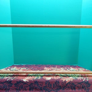 May include: A wooden embroidery hoop with a natural wood finish. The hoop is made of two pieces of wood that are joined together by a metal screw. The hoop is designed to hold fabric taut for embroidery.