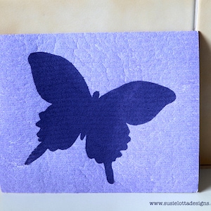 Peut inclure: Une carte violette avec une silhouette de papillon bleu foncé.