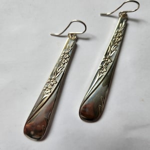 May include: A pair of silver earrings made from vintage silverware with a floral design.