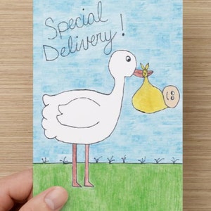 May include: A white stork with a red beak and legs is carrying a yellow baby in a white diaper. The stork is standing on a green field with a blue sky in the background. The text "Special Delivery!" is written in black above the stork.