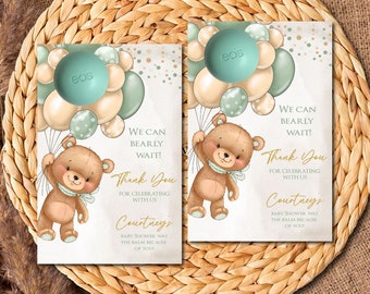 May include: Two baby shower favor tags with a teddy bear holding balloons. The tags are decorated with a light blue and white color scheme and gold glitter. The text on the tags reads "We can bearly wait! Thank you for celebrating with us. Courtneys Baby Shower was the balm because of you."