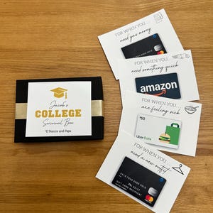 May include: A black gift box with gold accents and the text "Jacob's College Survival Box." Several gift cards are arranged around the box, including Amazon and Uber Eats cards, and a gift card for gas money.