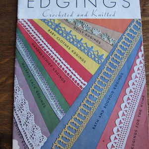 May include: A vintage book titled "The Book of Edgings: Crocheted and Knitted" with a price of 10 cents. The cover features a colorful collage of different crocheted and knitted edgings, including doily, baby clothes, handkerchief, hairpin lace, and knitted edgings.