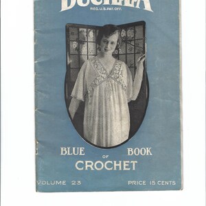 Puede incluir: Una portada de libro azul con el título "BUCILLA BLUE BOOK OF CROCHET" y el texto "VOLUME 23 PRICE 15 CENTS". La portada presenta una foto en blanco y negro de una mujer con un vestido de ganchillo.