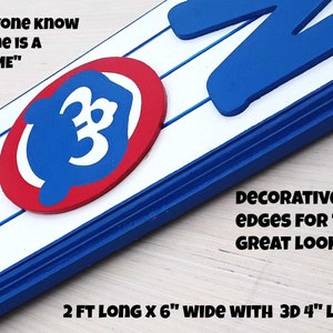 May include: A wooden sign with the word "HOME" in blue 3D letters, a red circle with a blue outline and a white "C" inside, and the text "Let everyone know your home is a "CUBS HOME"". The sign is 2 feet long and 6 inches wide with 3D 4-inch letters. The edges of the sign are decorated with routed edges.