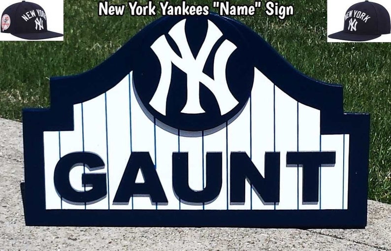 Pu&ograve; includere: Un cartello in legno con il nome "GAUNT" in grandi lettere nere. Il cartello &egrave; in stile New York Yankees, con un design a colori blu e bianco e il logo iconico dei Yankees di New York.