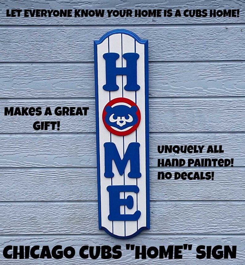 May include: A wooden "HOME" sign with a Chicago Cubs logo in the center. The sign is painted in blue, white, and red, with the letters "HOME" in white and the Cubs logo in blue and red. The sign is hanging on a blue wooden wall. The text "LET EVERYONE KNOW YOUR HOME IS A CUBS HOME!" is at the top of the image. The text "MAKES A GREAT GIFT!" is on the left side of the image. The text "UNQUELY ALL HAND PAINTED! NO DECALS!" is on the right side of the image. The text "CHICAGO CUBS "HOME" SIGN" is at the bottom of the image.
