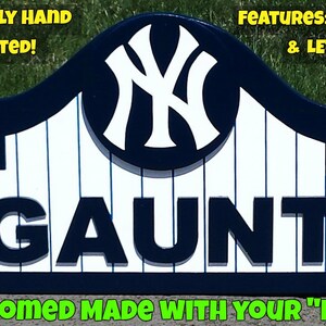 Pu&ograve; includere: Un cartello in legno personalizzato con un logo 3D dei New York Yankees e il nome "GAUNT" in lettere 3D. Il cartello &egrave; dipinto in blu navy e bianco, con uno sfondo bianco e strisce blu navy. Il cartello &egrave; fatto su ordinazione con il tuo nome.