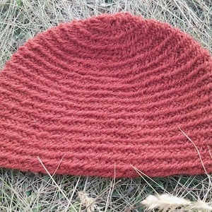 Puede incluir: Un gorro de punto rojo con textura de canalé. El gorro está hecho de un hilo suave y cálido, perfecto para mantener la cabeza caliente en invierno.