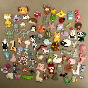 May include: A collection of colorful animal-shaped embellishments, including a dog, zebra, flamingo, and many more. These small, decorative pieces are in various colors and designs, perfect for crafting or adding a playful touch to projects.