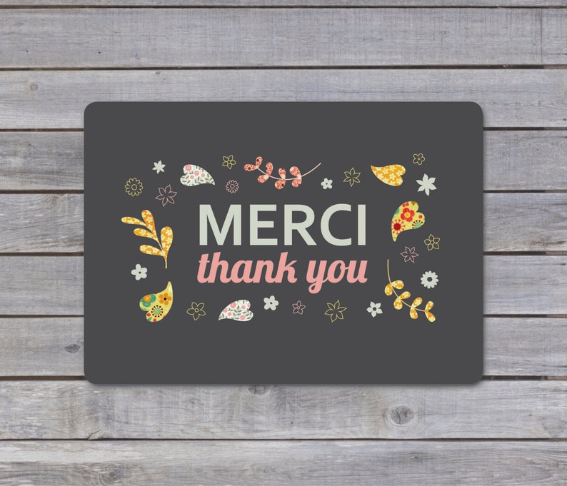 May include: A dark gray card with a floral border and the text "MERCI thank you" in white and pink.
