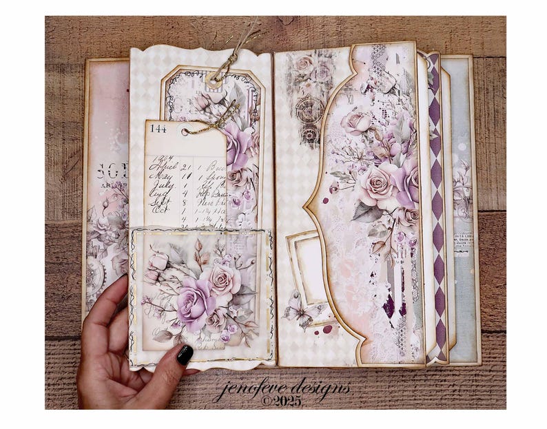 May include: Open scrapbook with floral and vintage-style designs. The pages feature soft pink and purple roses, decorative tags, and handwritten notes. The overall aesthetic is romantic and antique.