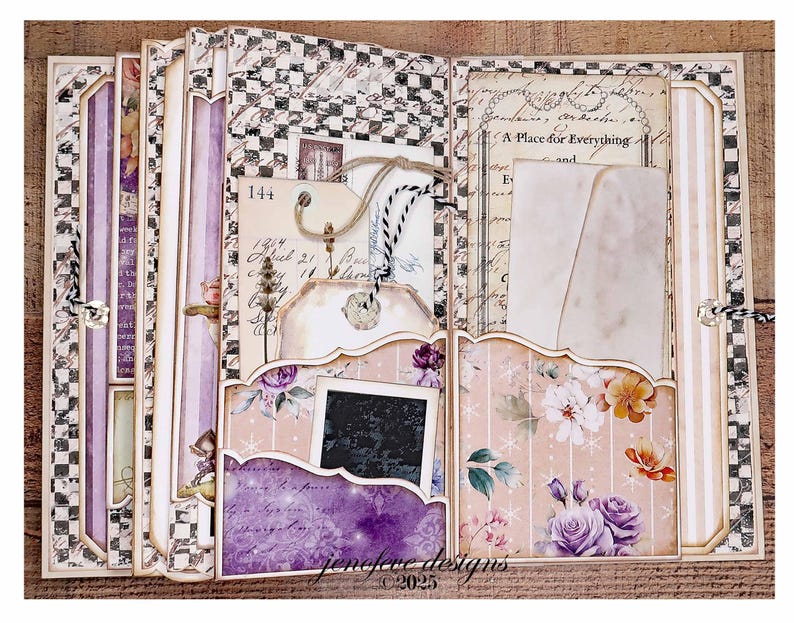 May include: A handmade scrapbook with a vintage aesthetic. The pages feature floral patterns, tags, and pockets. The color palette includes soft pinks, purples, and creams, with accents of black and white checkered patterns. The text "jenefere designs &copy;2025" is visible.