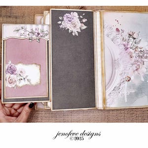 May include: A handmade scrapbook album with a mauve cover and floral embellishments. The album features a decorative frame and a dark gray page with a floral arrangement. The design includes the text "jenofeve designs &copy;2025".