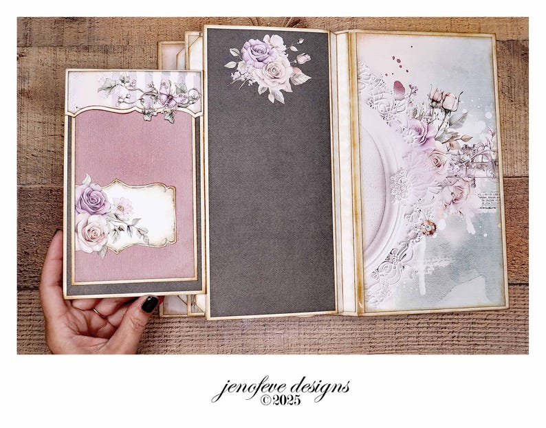 May include: A handmade scrapbook album with a mauve cover and floral embellishments. The album features a decorative frame and a dark gray page with a floral arrangement. The design includes the text "jenofeve designs &copy;2025".