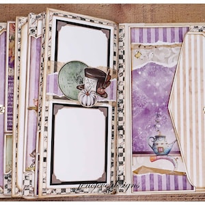 May include: A handmade scrapbook with an Alice in Wonderland theme. The pages feature purple and white stripes, blank photo frames, and decorative elements like a clock, hat, and pumpkin. The edges are adorned with a black and white checkered pattern.