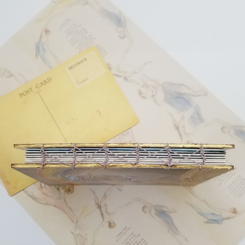 Picture shows the spine of the handmade artist book, which features handsewn stitch binding, to allow the book to open flat