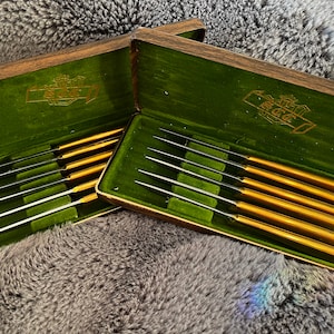 May include: A set of three ceramic mugs with a speckled, matte finish. The mugs are in shades of cream, light grey, and dark grey. Each mug has a simple, minimalist design, ideal for coffee or tea.