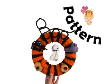 May include: Crocheted Halloween wreath in orange and black stripes, adorned with a spider, ghost, and purple creature. The wreath has two pumpkin accents and the word "pattern" is written in black. A giraffe holding heart balloons is also in the image.