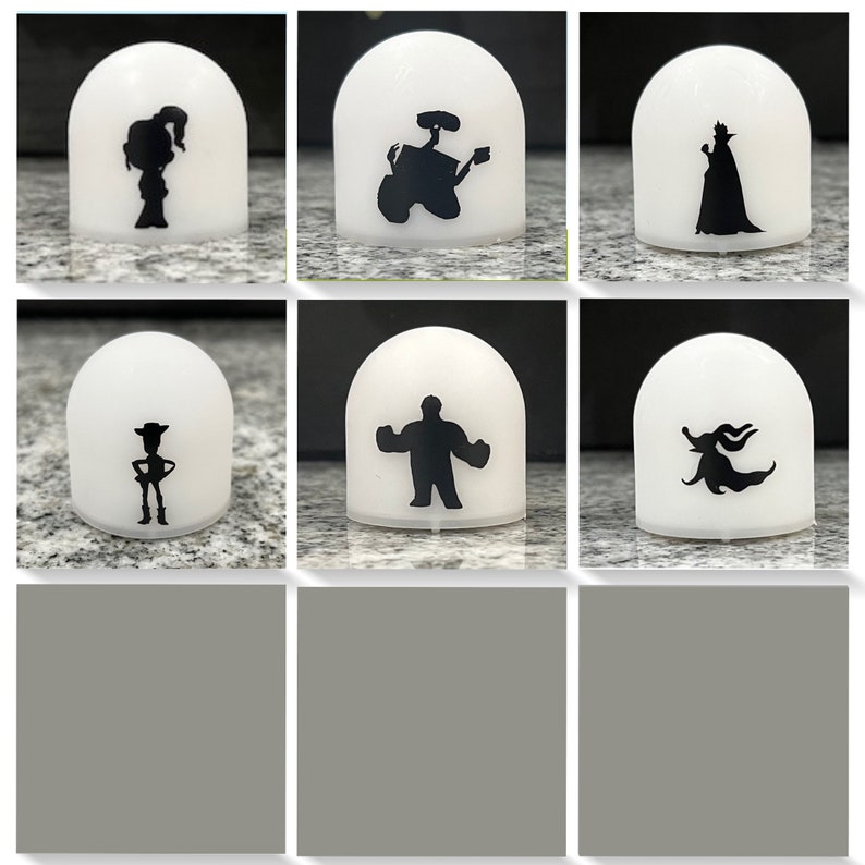 May include: Set of six white dome-shaped night lights with black silhouettes of Disney characters. The characters include: Woody, Buzz Lightyear, Sulley, Mike Wazowski,  Boo, and Ursula.