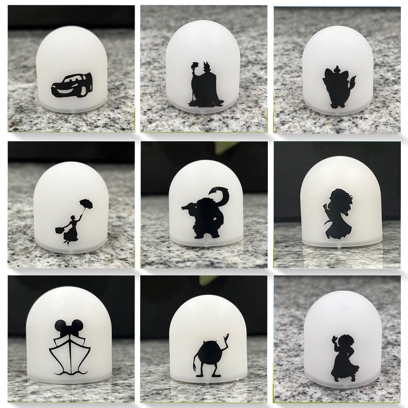 May include: Nine white dome-shaped night lights with different Disney character silhouettes. The characters include:  Cars,  Maleficent,  Ariel,  The  Beast,  Mary Poppins,  Sulley,  Mickey Mouse,  Mike Wazowski, and  Tiana.