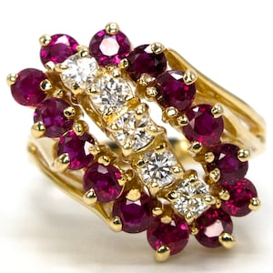 May include: A gold ring with a cluster of red rubies and diamonds. The rubies are set in a row around the band, with the diamonds set in a row above them.